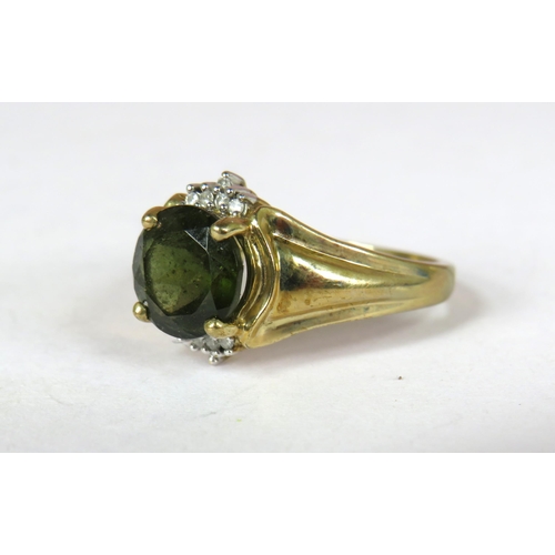 360 - 9ct Yellow Gold ring set with a circular Green Tourmaline flanked by Melee Diamonds to both sides.  ... 