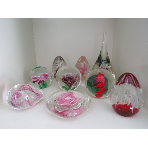 530 - Nine art glass paperweights pink, purple and red colours with internal flowers and swirls.