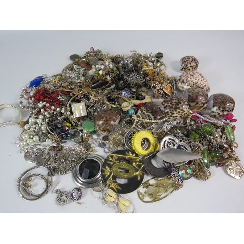 573 - Over 3.5kgs of costume jewellery and a set of cowrie shell napkin rings.