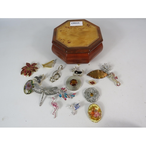 586 - Small wooden jewellery box with a collection of brooches including a 925 silver scottish brooch.