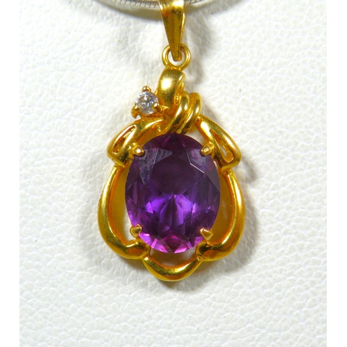 695 - Unmarked Yellow Metal pendant set with a deep coloured central Amethyst. See photos.