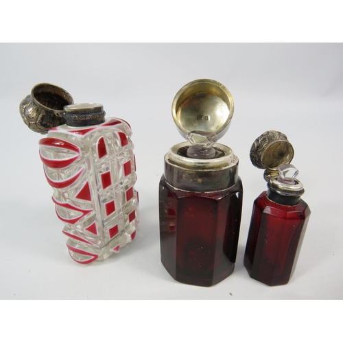 12 - Three antique silver topped scent bottles, cranberry and cut to clear. One is missing a stopper.