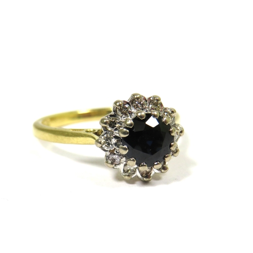 323 - 18ct Yellow Gold Ring set with a Central Circular Sapphire with Diamond Surround. Finger size 'M'   ... 