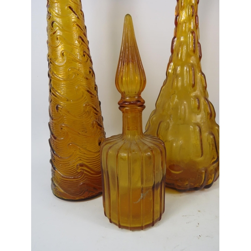 284 - Three Amber Italian glass Empoli style genie bottles plus one smaller. Three with stoppers.