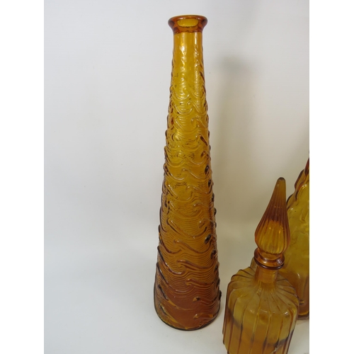 284 - Three Amber Italian glass Empoli style genie bottles plus one smaller. Three with stoppers.