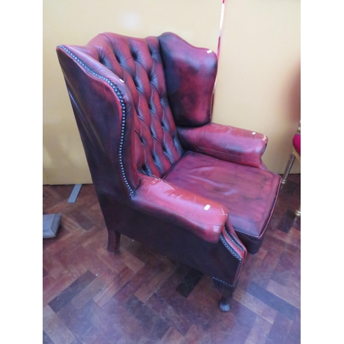 560 - Vintage Red Leather Chesterfield wing back chair in worn condition. Will need patches to arms. See p... 