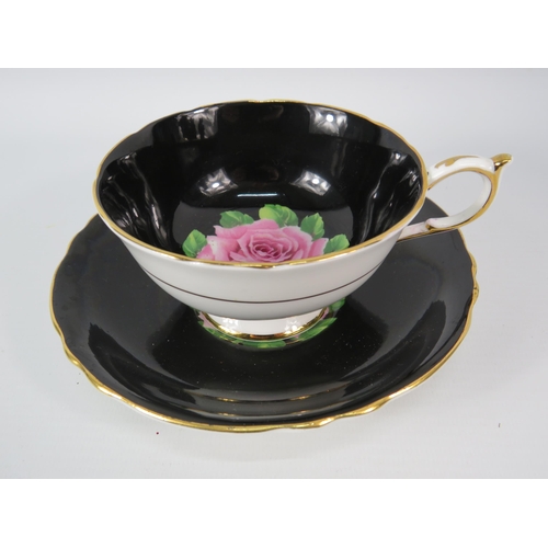 28 - Vintage Paragon china black cup and saucer with central pink rose.