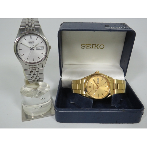 144 - Two Gents Seiko Quart Watches, one in Silver tone and one Gold tone. One with box. Both have date wi... 