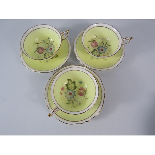 25 - Three Paragon china cups and saucers, yellow and white with floral decoration inside the bowl and on... 