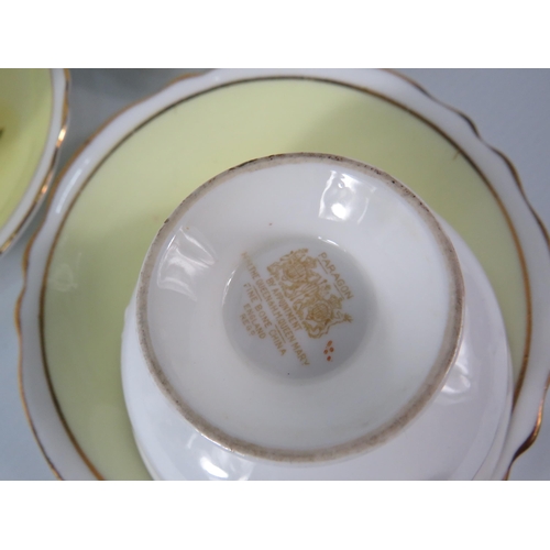 25 - Three Paragon china cups and saucers, yellow and white with floral decoration inside the bowl and on... 