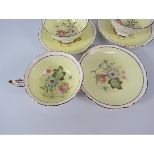 25 - Three Paragon china cups and saucers, yellow and white with floral decoration inside the bowl and on... 