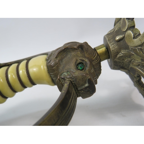 723 - Pair of c1920s WW1 Imperial German Navy Lions Head Sword candle holders, The lions have one green an... 