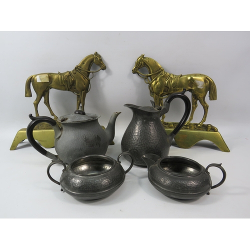 1106 - A pair of brass horse fire dogs and a hammered pewter teaset.