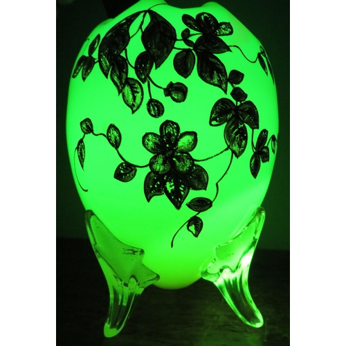 51 - An Opaline uranium glass egg shaped vase with ruffled rim and gilded decoration standing on three cl... 