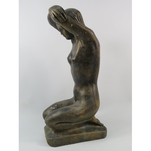 76 - A Concrete bronze painted statue of a Nude lady kneeling with her arms above her head, 19.5