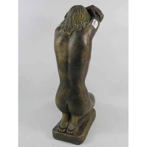 76 - A Concrete bronze painted statue of a Nude lady kneeling with her arms above her head, 19.5