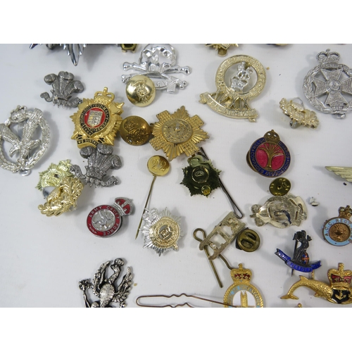 133 - Large selection of mainly reproduction military cap badges plus some enamel pin badges.