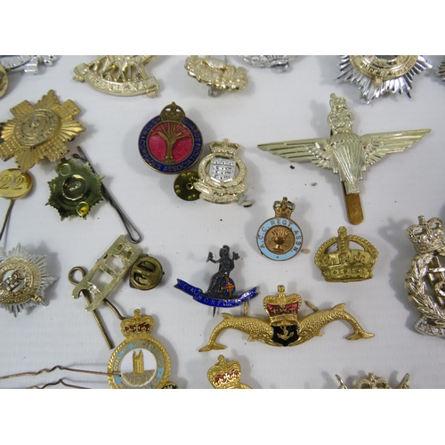 133 - Large selection of mainly reproduction military cap badges plus some enamel pin badges.