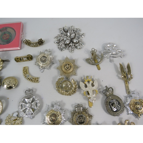 133 - Large selection of mainly reproduction military cap badges plus some enamel pin badges.