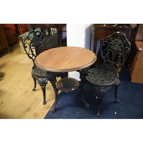 1216 - Garden Patio set comprising of a  wooden topped metal table with pierced decoration together with tw... 