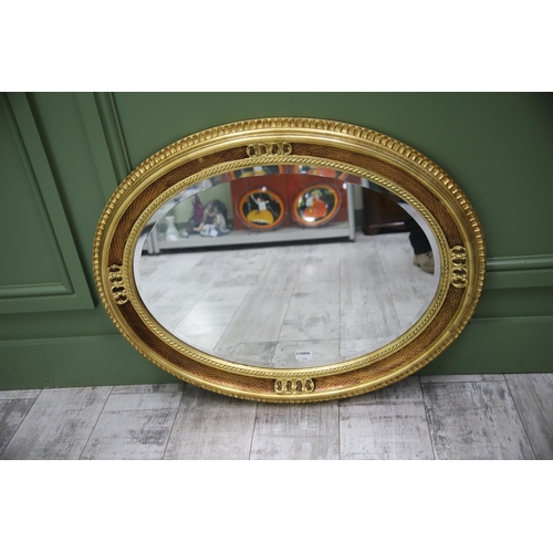 950 - Large Modern Ornate Oval Mirror with a Gilded frame and bevelled glass. Measures approx 27 x 34 inch... 