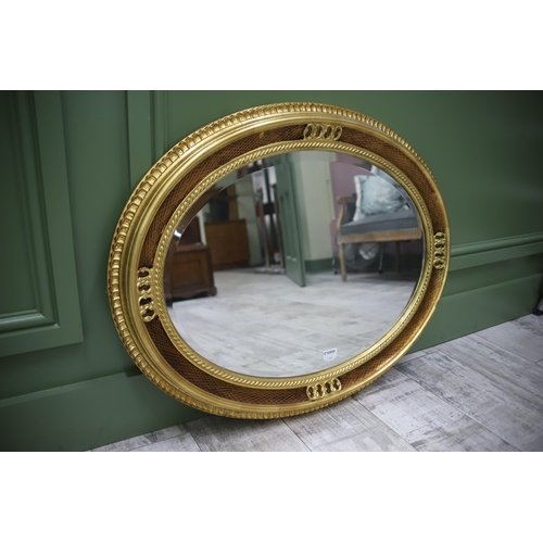 950 - Large Modern Ornate Oval Mirror with a Gilded frame and bevelled glass. Measures approx 27 x 34 inch... 