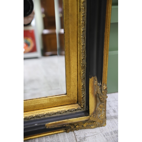 951 - Large Rectangular ornate mirror with Black and Gilt frame with Bevelled Glass.. Measures approx 24 x... 