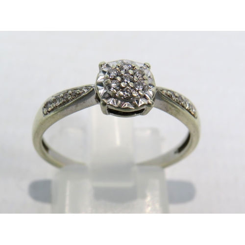 270a - 9ct White Gold Diamond ring, Seven central diamonds & four to each shoulder .15ct, size R. 2.6 grams