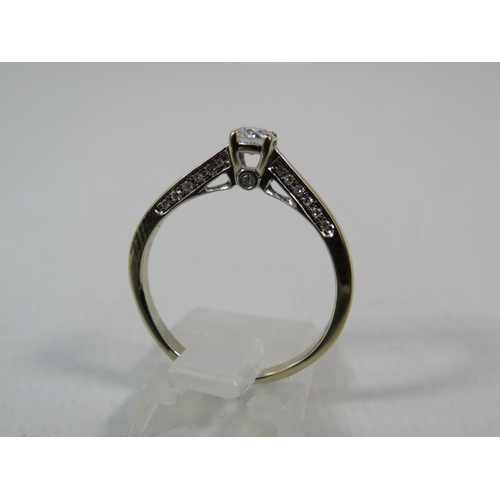 284a - 18ct White gold .40ct diamond solitaire ring with Accents to the inner shoulders, finger size R. 3.3... 