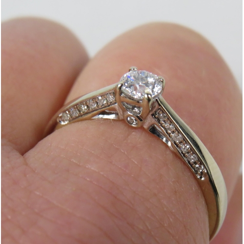 284a - 18ct White gold .40ct diamond solitaire ring with Accents to the inner shoulders, finger size R. 3.3... 