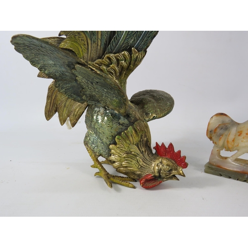 681 - Brass painted metal fighting cockerel plus a small onyx cockerel. The largest stands 10.5