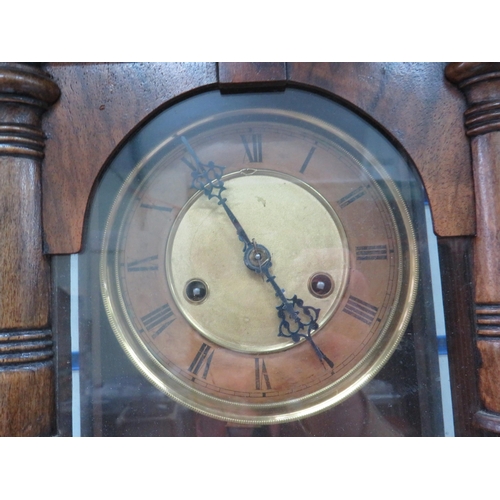 773 - Twin train chiming oak cased wall clock with key and pendulum in working order Measures approx 28 in... 