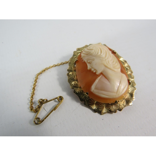 189 - Cameo brooch with 9ct gold surround and safety chain, total weight 6.2 grams. 38mm by 32mm.