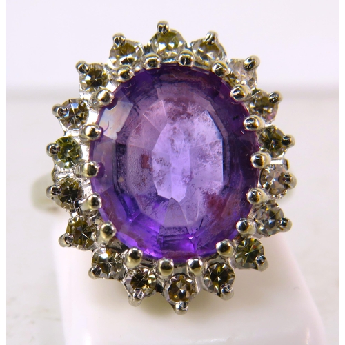 325 - 18ct White gold ring set with a large central Amethyst (12mm by 10mm) and surrounded by diamonds, fi... 