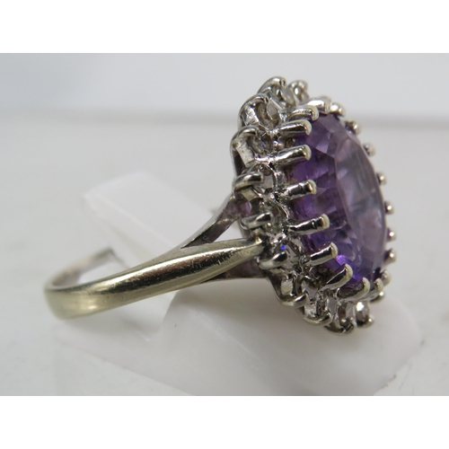 325 - 18ct White gold ring set with a large central Amethyst (12mm by 10mm) and surrounded by diamonds, fi... 