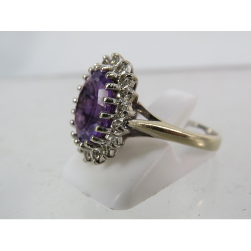 325 - 18ct White gold ring set with a large central Amethyst (12mm by 10mm) and surrounded by diamonds, fi... 