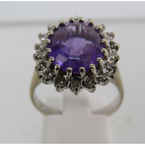 325 - 18ct White gold ring set with a large central Amethyst (12mm by 10mm) and surrounded by diamonds, fi... 