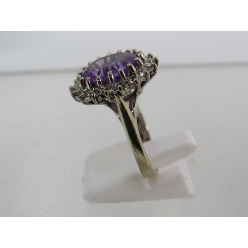 325 - 18ct White gold ring set with a large central Amethyst (12mm by 10mm) and surrounded by diamonds, fi... 