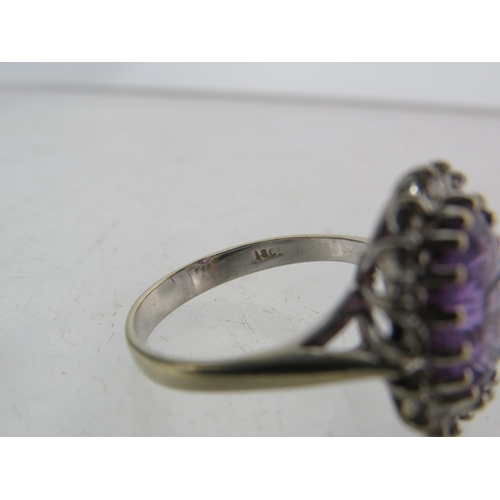 325 - 18ct White gold ring set with a large central Amethyst (12mm by 10mm) and surrounded by diamonds, fi... 