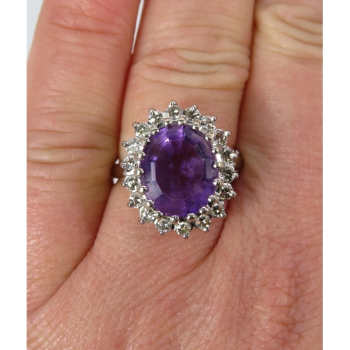 325 - 18ct White gold ring set with a large central Amethyst (12mm by 10mm) and surrounded by diamonds, fi... 