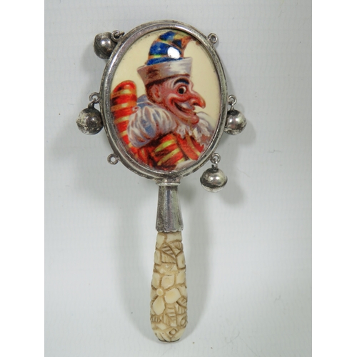 1009 - Childs Antique teether/Rattle, (two small bells missing)  Mr Punch enamel panel.  Measures approx 95... 