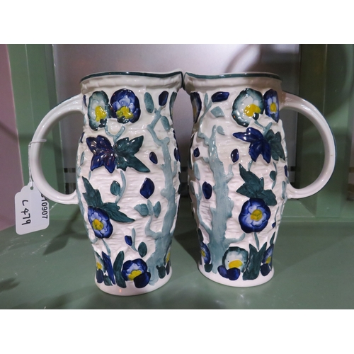 479 - Pair of hand-painted ceramic jugs with floral and foliate relief decoration, approx. 10 inches high,... 