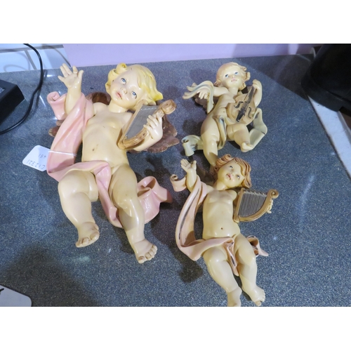 481 - Group of three vintage wall-mounted cherub figures in painted composition, each modelled playing mus... 
