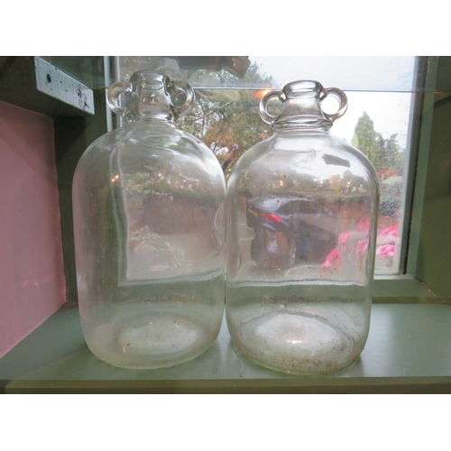 486 - Pair of large clear glass demijohn bottles, approx. 13 inches tall.