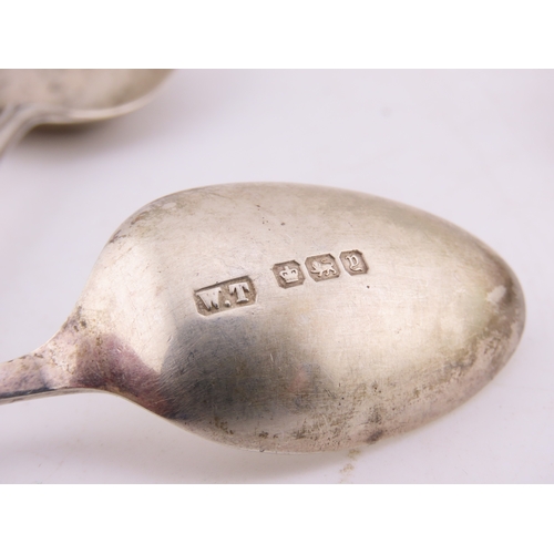 129 - A group of five Sheffield-hallmarked souvenir teaspoons, each with ornate cast terminals depicting c... 