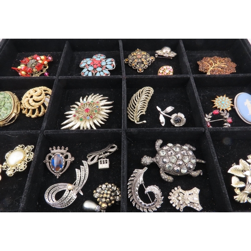 82 - Tray of vintage brooches A comprehensive assortment of brooches displayed in a compartmented tray, f... 