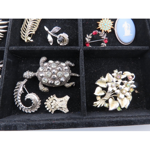 82 - Tray of vintage brooches A comprehensive assortment of brooches displayed in a compartmented tray, f... 