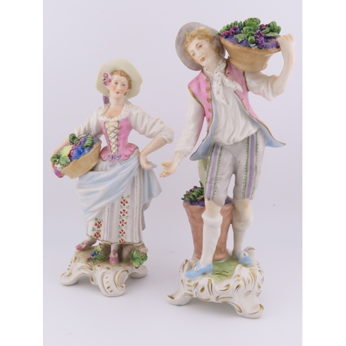 175 - Rudolf Kammer porcelain figures of a vineyard couple, the lady carrying a basket of grapes and the g... 