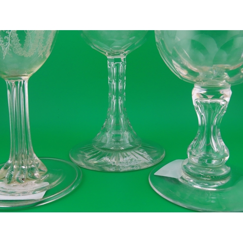 179 - Three large drinking glasses comprising a goblet with shell and scroll engraving, a faceted stem exa... 