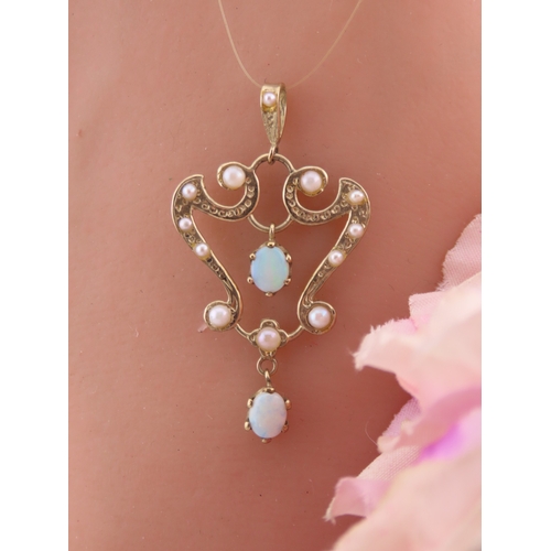 312 - A 9ct gold pendant of openwork heart form, set with opals and seed pearls. The stones displaying cha... 